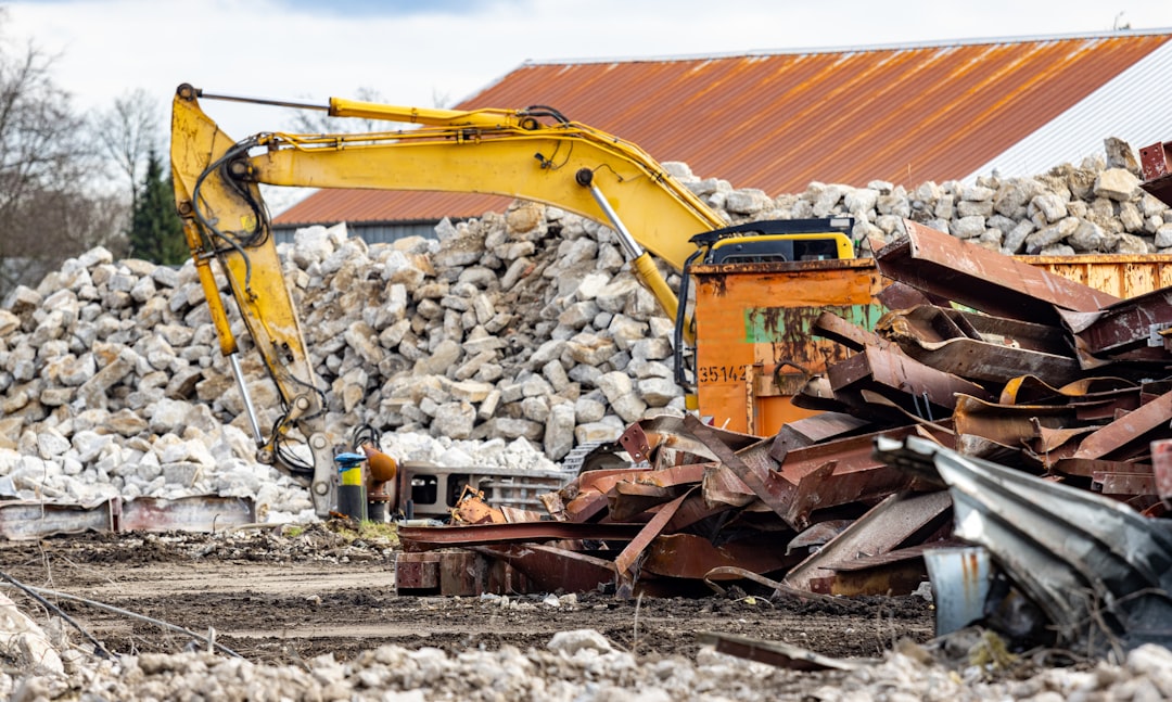 a-pile-of-rubble-next-to-a-yellow-excavator-wuq9kboarsk