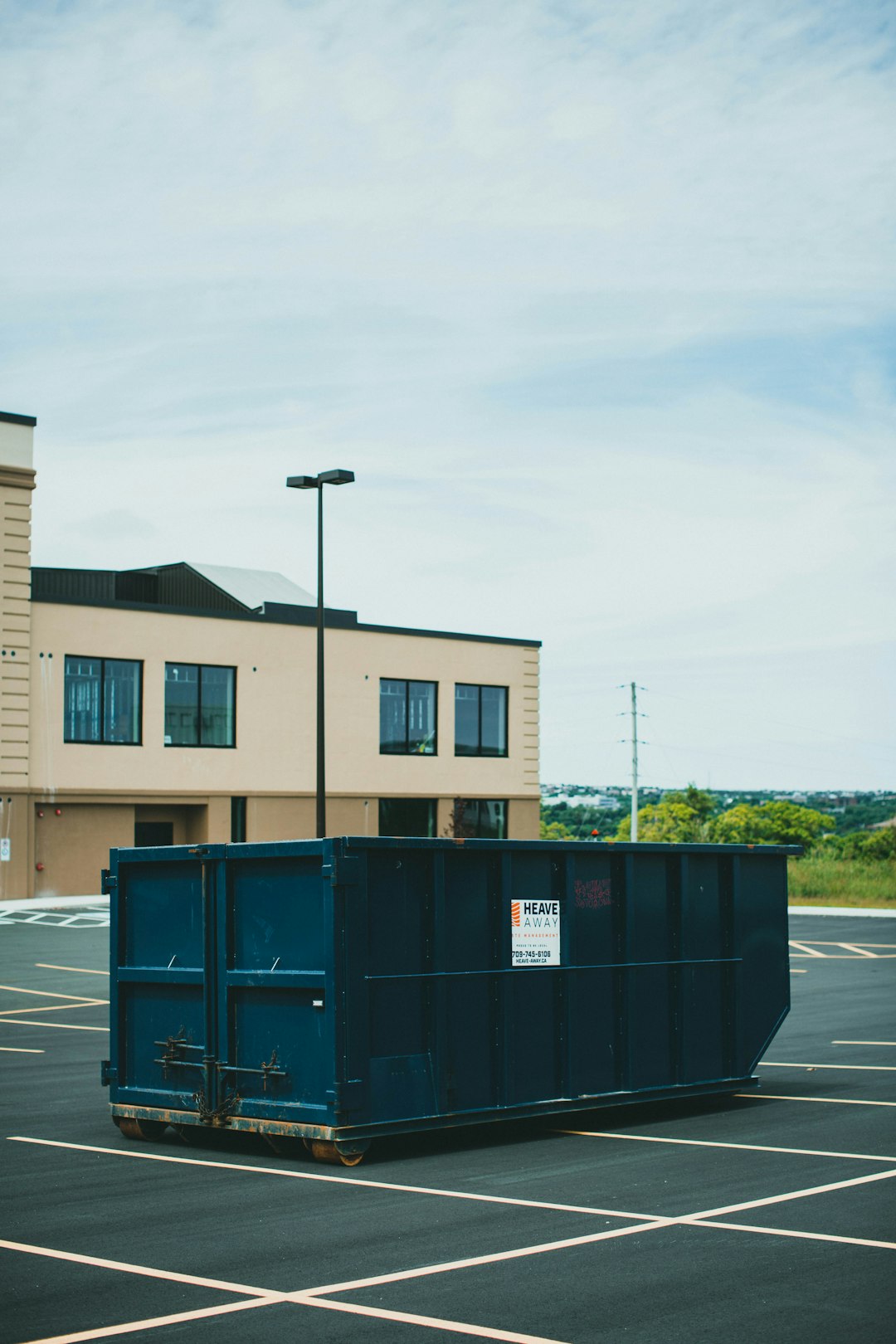 blue-trash-bin-beside-brown-concrete-building-during-daytime-rpzugz-zlf4