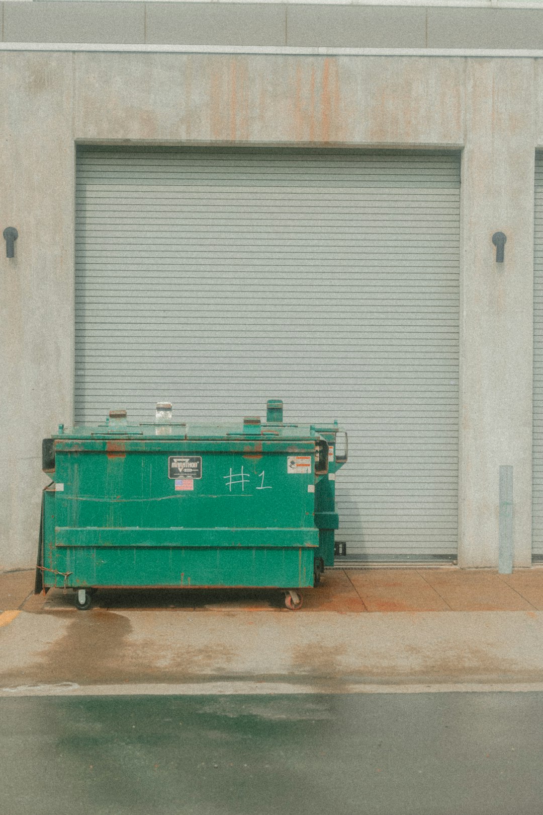 dumpsters-are-near-a-closed-loading-dock-gnwy8fuv7qs